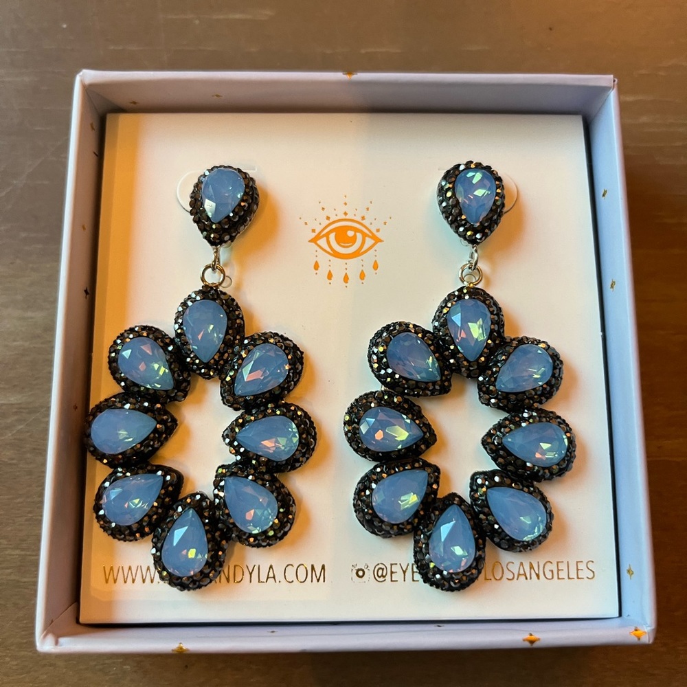 Never Worn and still in its box, these sparkly blue earrings are from Eye Candy.
